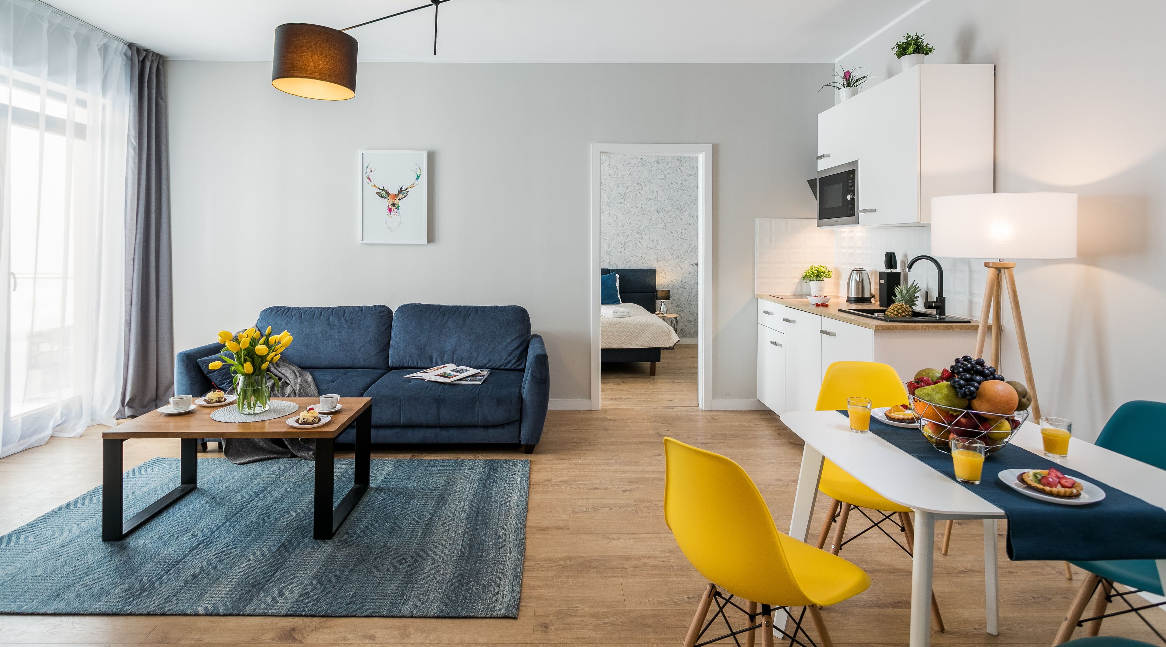 A modern apartment with a living room, dining area, and kitchen.