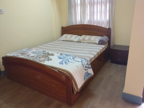 Ein Schlafzimmer mit einem Holzbett, einem Nachttisch und einer Kommode.