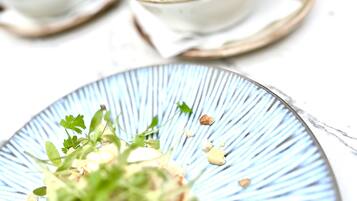 A plate with a green salad and a bowl of mixed greens in the background.