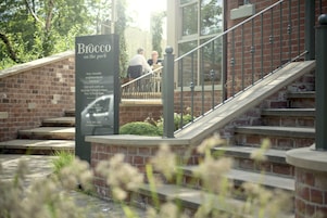 Señal que dice 'Brocco on the park' con una escalera que lleva a un edificio de ladrillo.