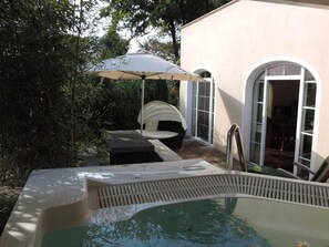 A swimming pool with a hot tub, a covered seating area, and a door leading to a room. - Park-Villa (Kressbronn)