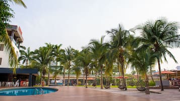 Una piscina al aire libre, sombrillas, tumbonas