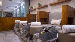 A spa area with multiple seating options, a reception desk, and shelves with toiletries. - Francis Hotel (Abuja)