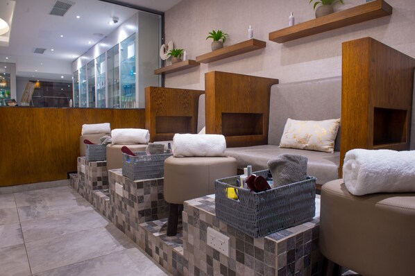 A spa area with multiple seating options, a reception desk, and shelves with toiletries.