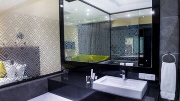 Un baño moderno con dos lavamanos, un espejo grande y papel tapiz estampado.