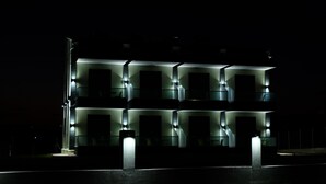 Un bâtiment moderne doté de nombreuses fenêtres illuminées la nuit.