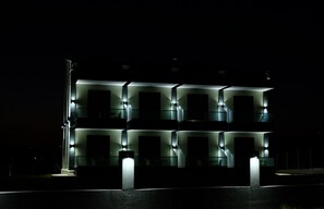 A modern building with multiple illuminated windows at night.