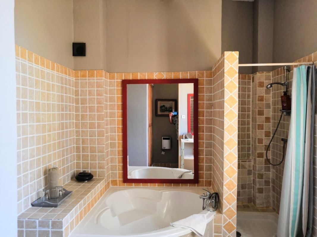 Un bagno con vasca, doccia e specchio.