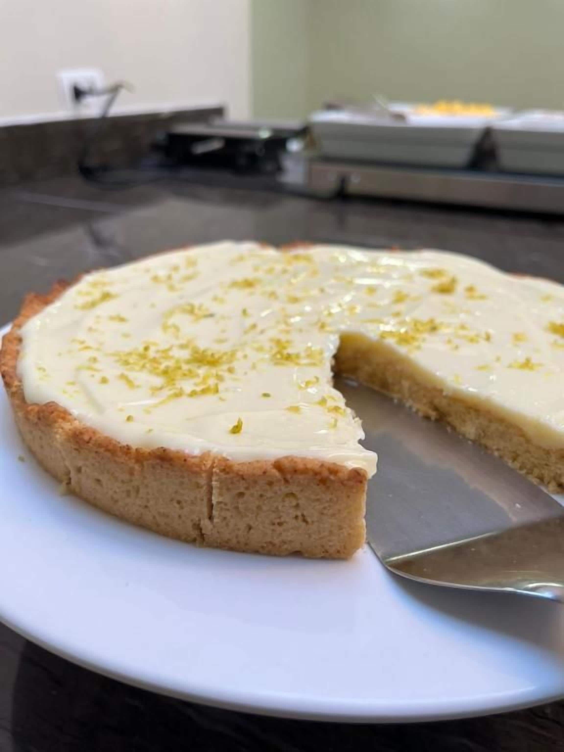 A slice of cheesecake on a white plate with a spatula.