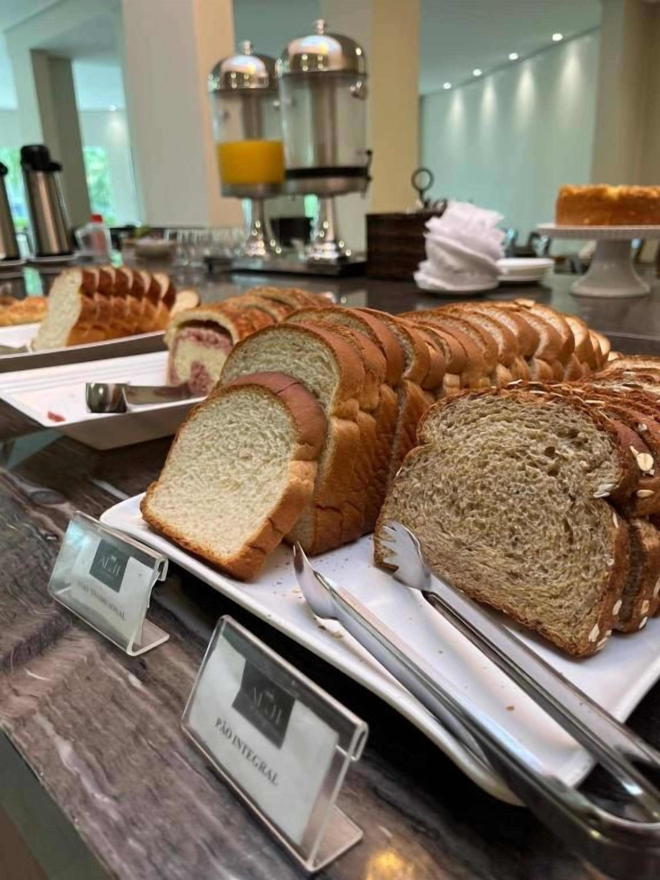 Ein Buffet mit verschiedenen Brotsorten, darunter ein Brioche-Laib und ein Vollkornbrot.