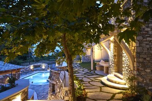 A stone pool with a stone pathway leading to a covered seating area. - Sunrise Pelion Villas Tsagkarada (Zagora-Mouresi)