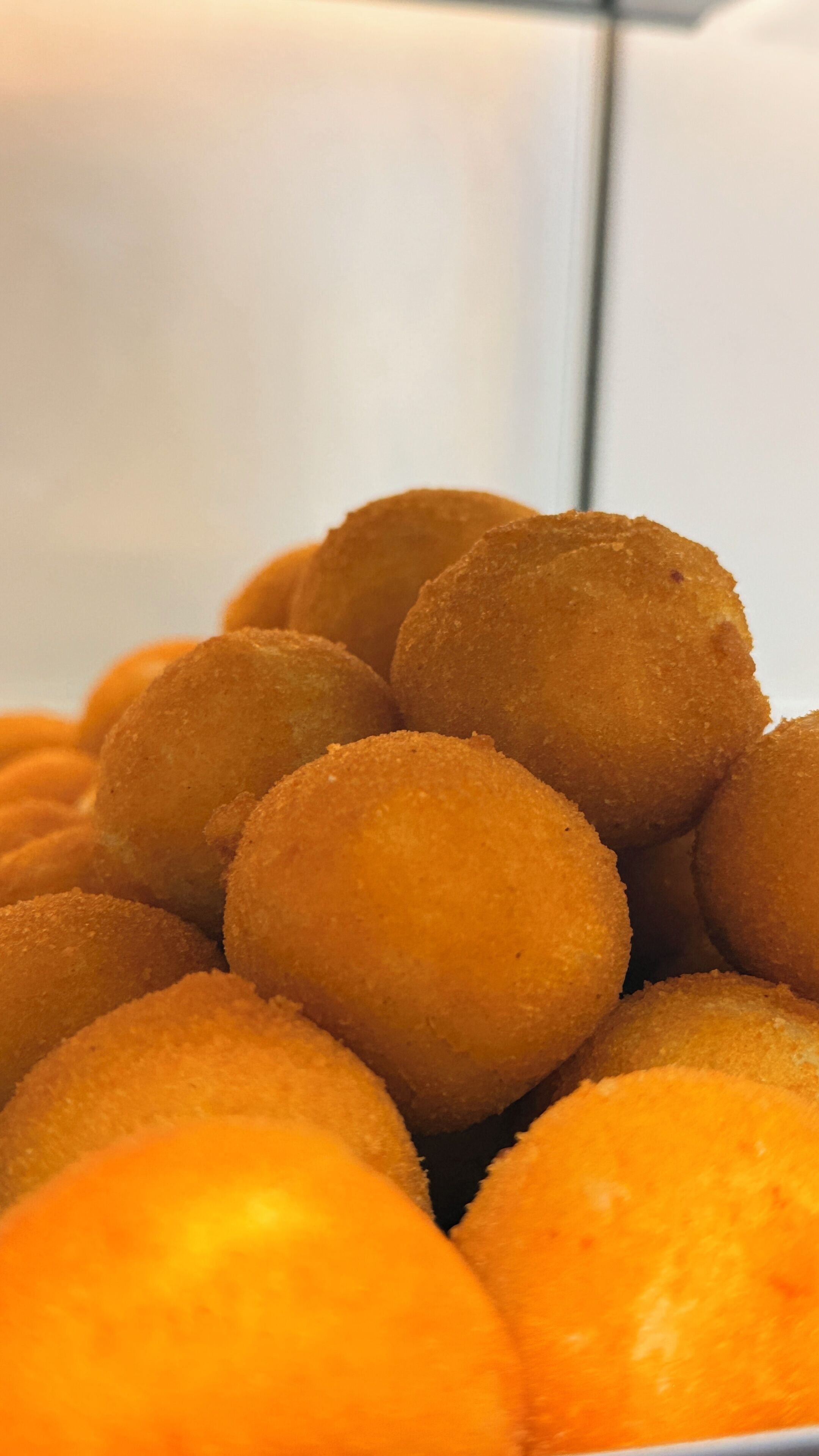 A close-up of golden-brown fried food items piled together.