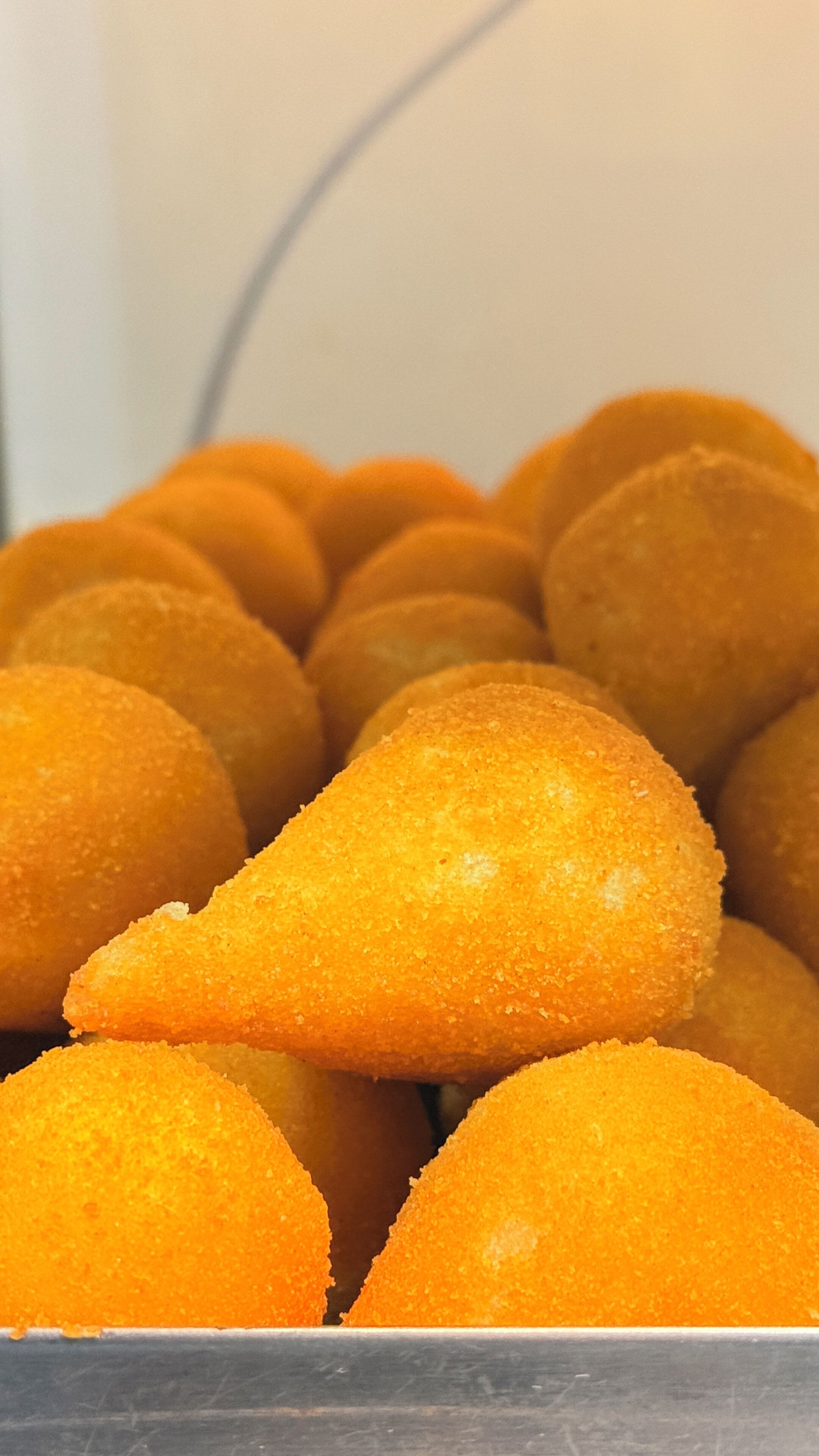 A close-up of golden-brown, breaded food items piled together.