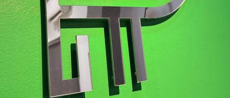 A metallic logo on a green background.