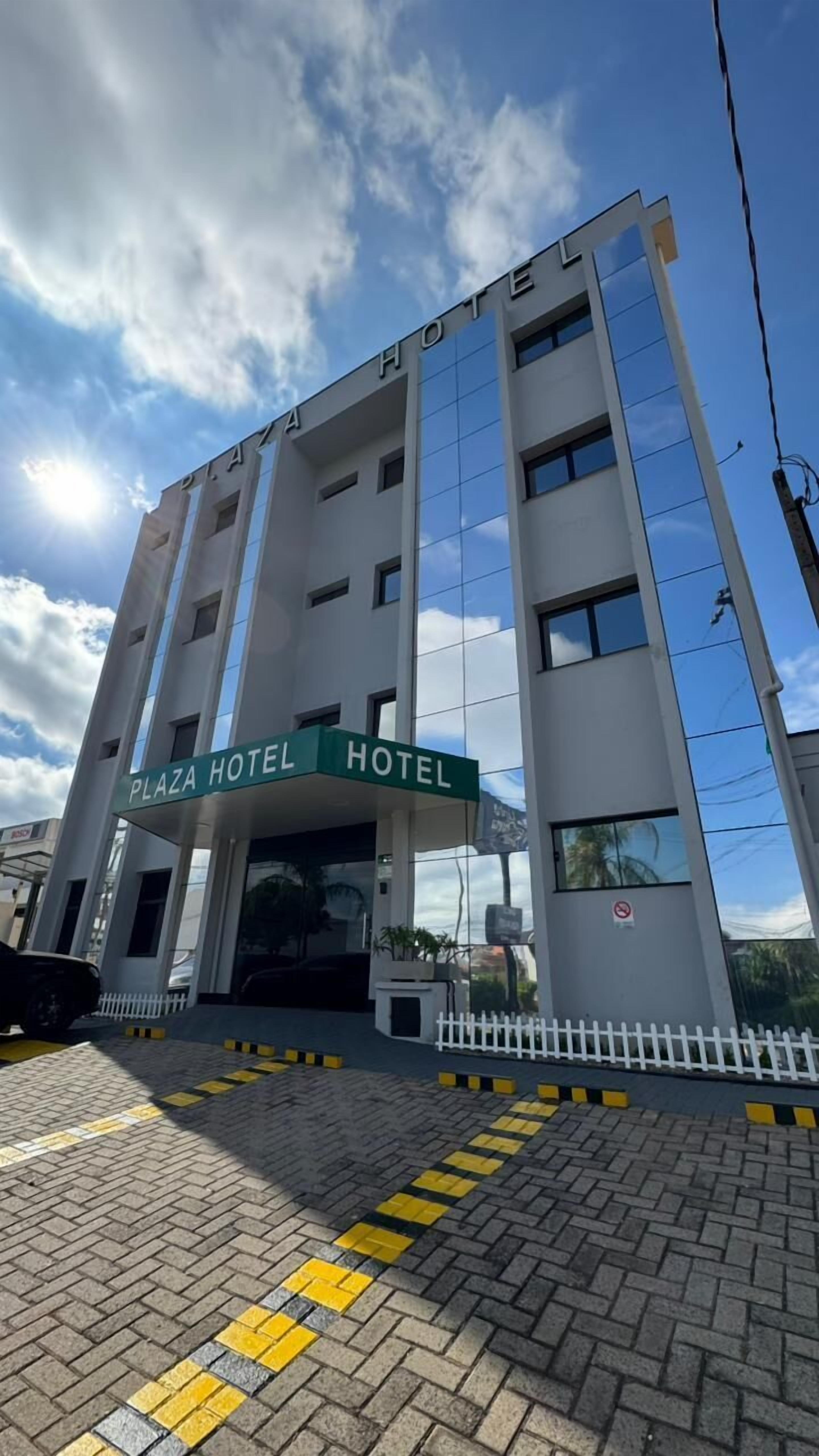 Um edifício de vários andares com uma placa indicando 'Plaza Hotel'.