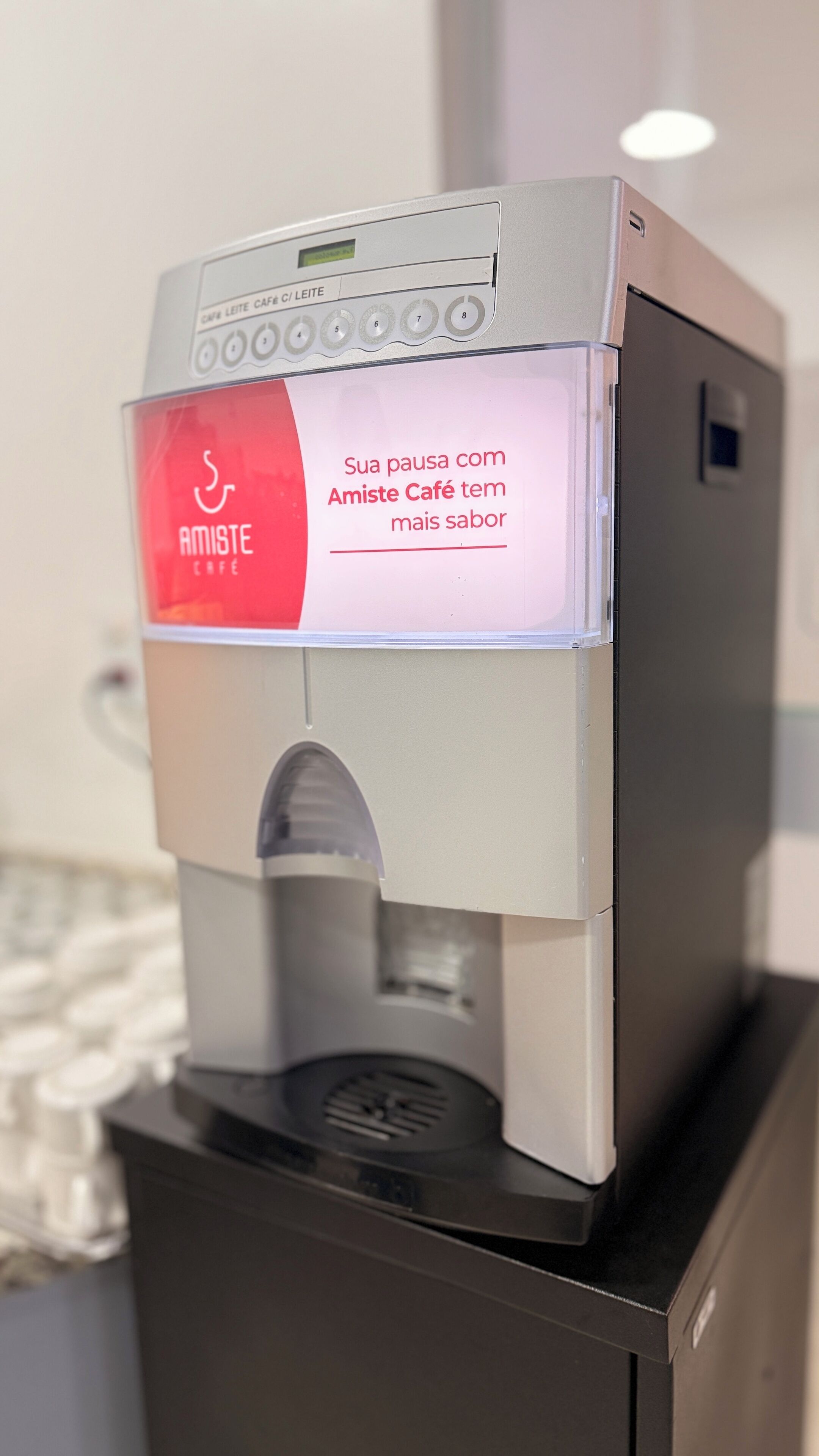 Una cafetera con pantalla digital y una etiqueta roja que dice 'Amiste Café'.