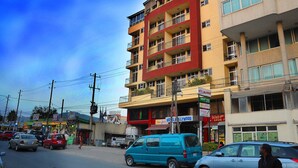 A multi-story hotel with balconies, a sign for 'Hotel Hollywood', and various shops on the ground floor. - Holly Wood Hotel (Addis Ababa)