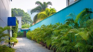 A paved pathway lined with potted plants and a blue wall on one side. - Atlantic Hotel and Spa (Lagos)