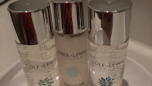 Three bottles of Cole & Lewis London body wash and conditioner, and shampoo, with a cap in front. - Lyndhurst Guest House (Keswick)