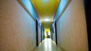 A long, narrow hallway with a tiled floor and walls painted in a light color. - Golden Destiny Hotel Limited (Lagos)