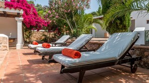 Una piscina al aire libre, sillones reclinables de piscina