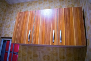 Une armoire avec une finition en bois et des poignées en métal.