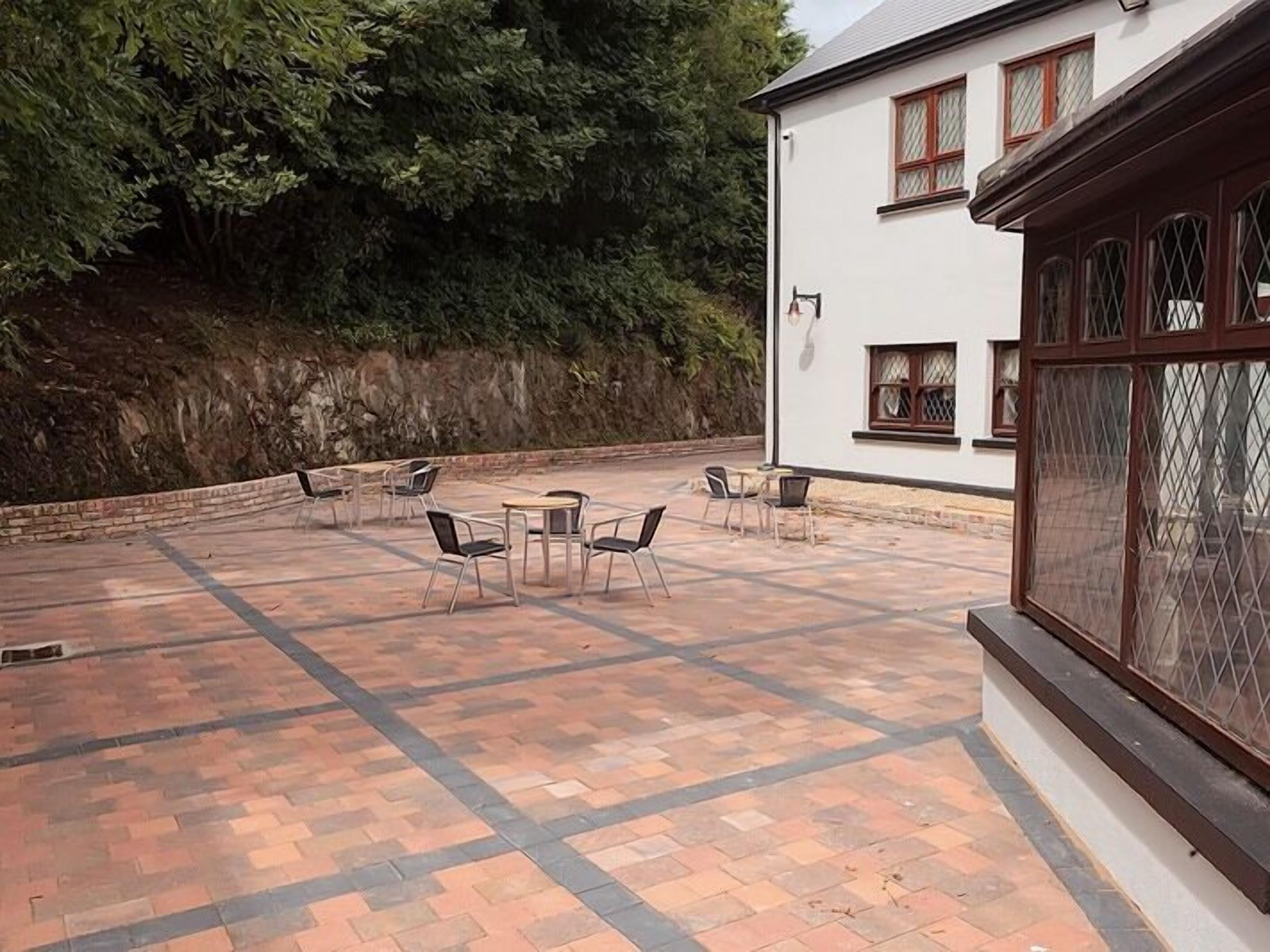 A patio with outdoor seating and a white building with windows.