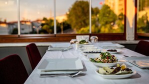 Una mesa de comedor lista para una comida, con platos de comida, cubiertos y vasos.
