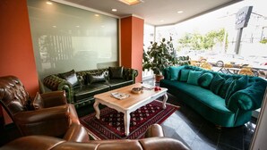 Una sala de estar moderna con sofás de cuero, una mesa de centro de madera y una alfombra roja estampada.
