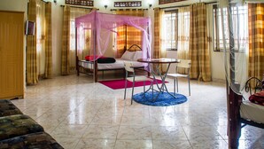 Une chambre à coucher avec un lit, une chaise, une table et une fenêtre.