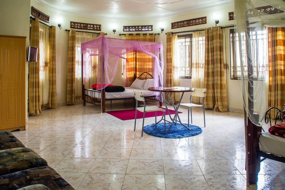 Une chambre à coucher avec un lit, une chaise, une table et une fenêtre.