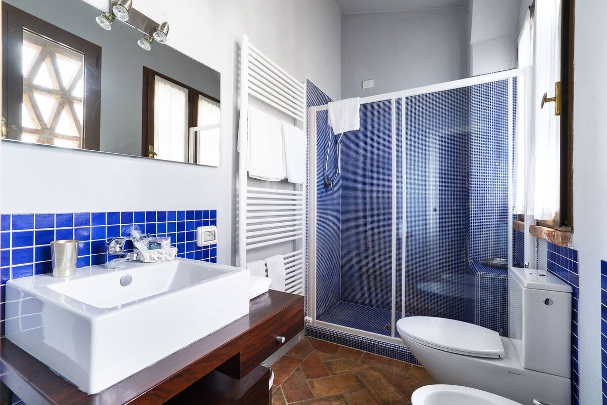 A bathroom with a white sink, a shower enclosure, and a toilet.