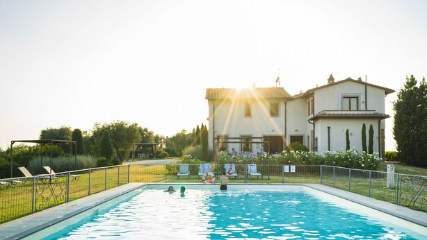 A swimming pool with a house in the background. - Agriturismo Cantagrillo (Vinci)
