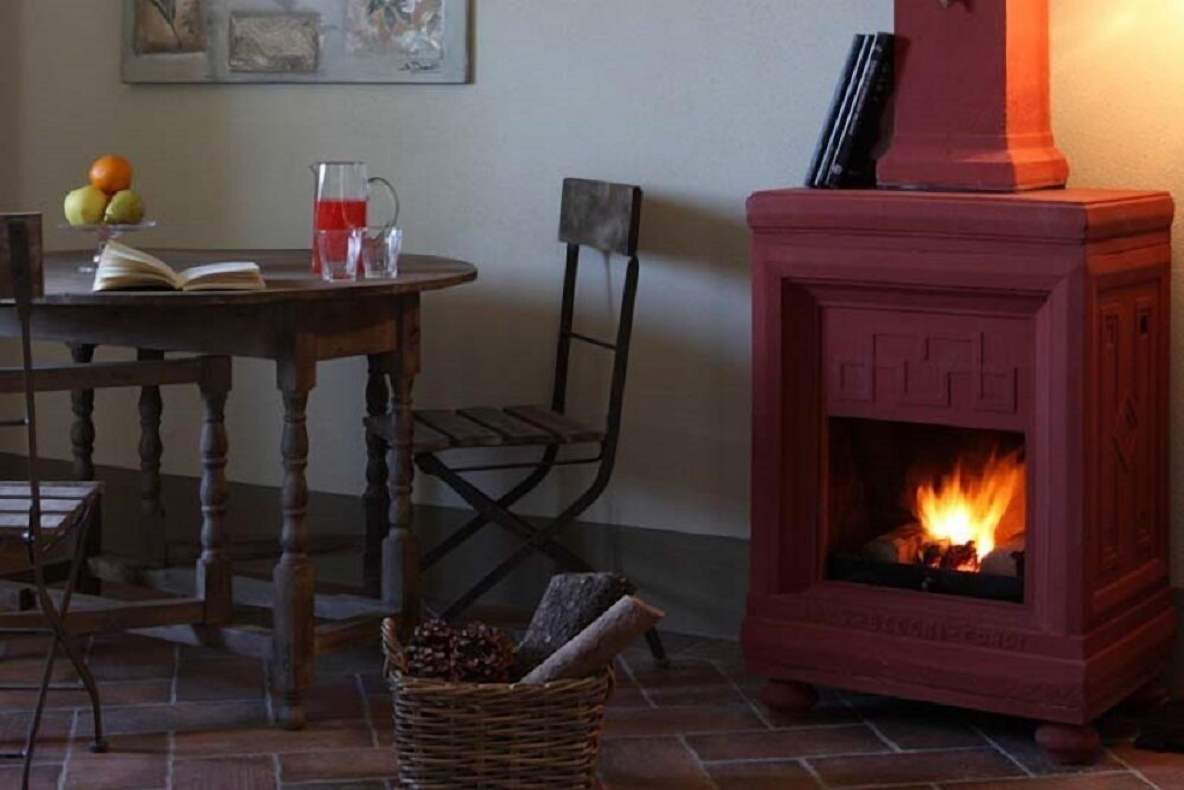 Ein gemütliches Zimmer mit Kamin, einem Tisch mit Buch und Obst sowie einem Korbwägelchen.