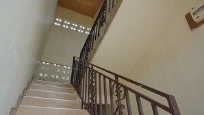 Una escalera con barandilla de madera y adornos metálicos.