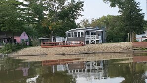 A lakeside cabin with a dock and a small boat.