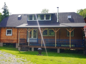 A wooden cabin with a porch, a chimney, and a small window. - Dirbach Plage Parc (Esch-sur-Sure)