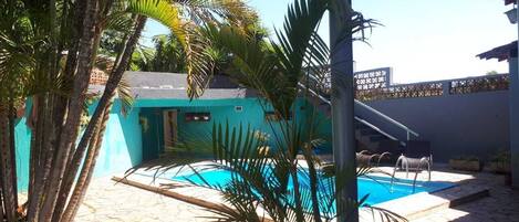 Una piscina al aire libre, sillones reclinables de piscina