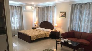 Ein Hotelzimmer mit Bett, Sofa, Couchtisch und Teppich.