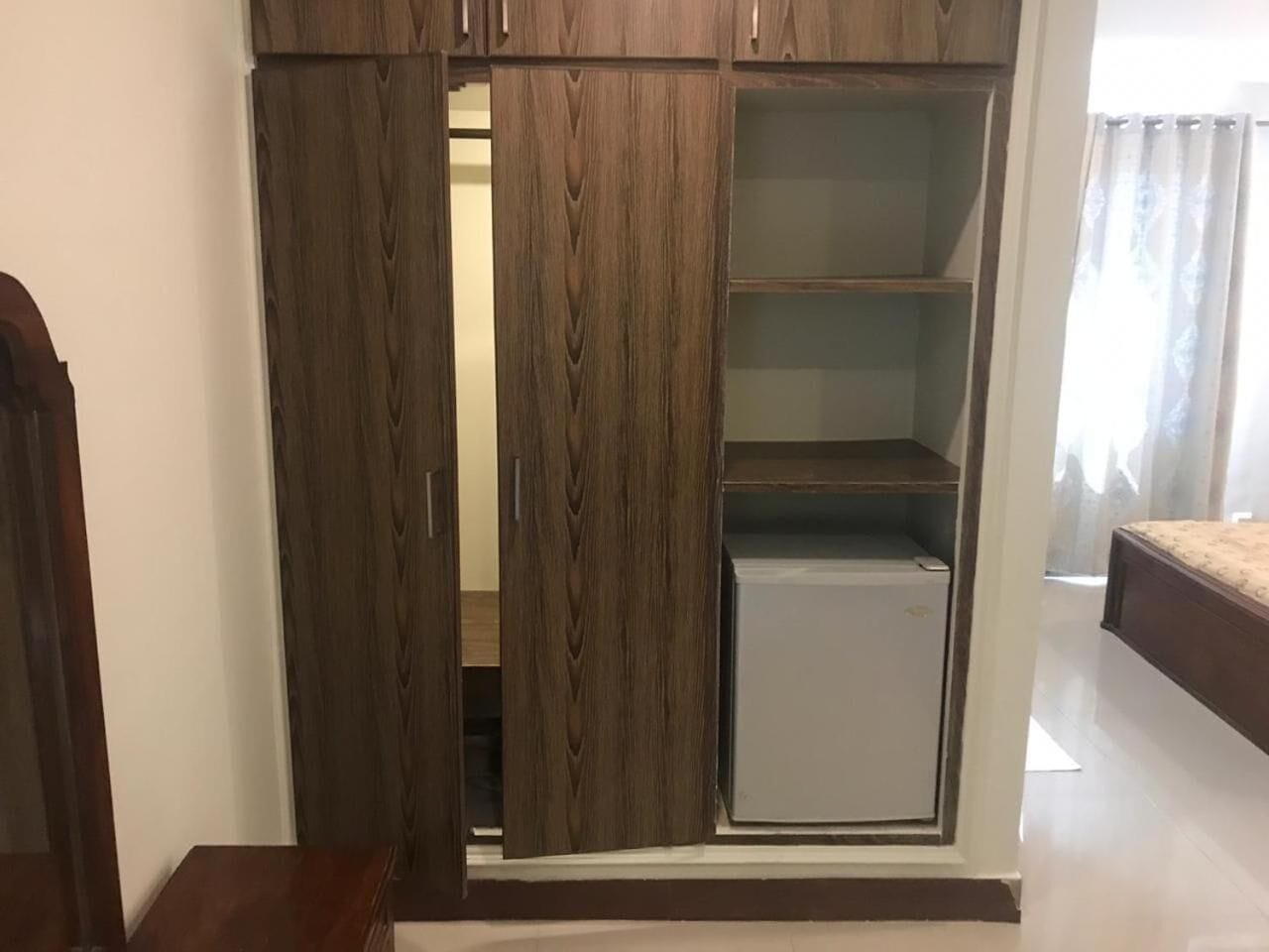 Ein Schlafzimmer mit Kleiderschrank, Bett und einem kleinen weißen Gerät.