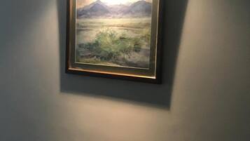 A framed landscape painting on a wall.