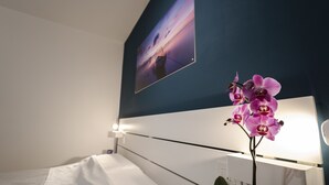 A hotel room with a bed, a nightstand, a lamp, and a wall-mounted picture. - La Palma del Sol (Barletta)