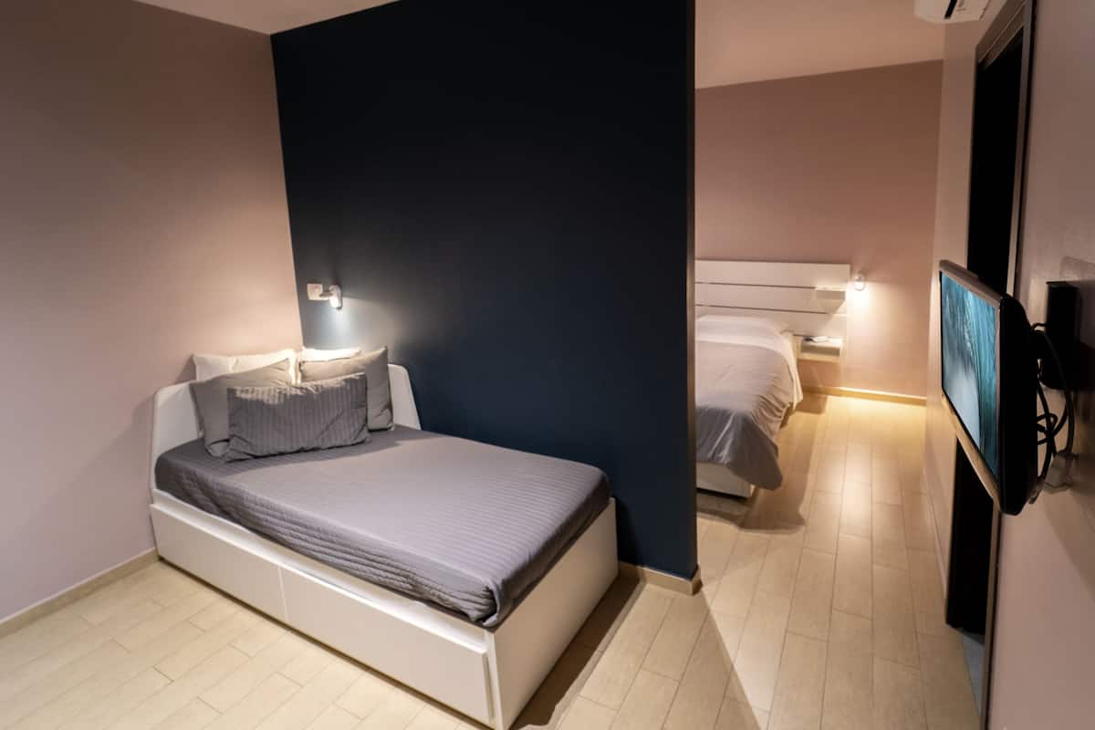 Une chambre à coucher moderne avec un lit, des lampes de chevet et un téléviseur.