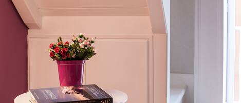 Un libro titulado "POLARIS" sobre una mesa blanca, junto a un florero rosa con flores.