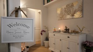 A home interior with a welcome sign, a cabinet, and a decorative wall piece. - Relais al Museo (Naples)