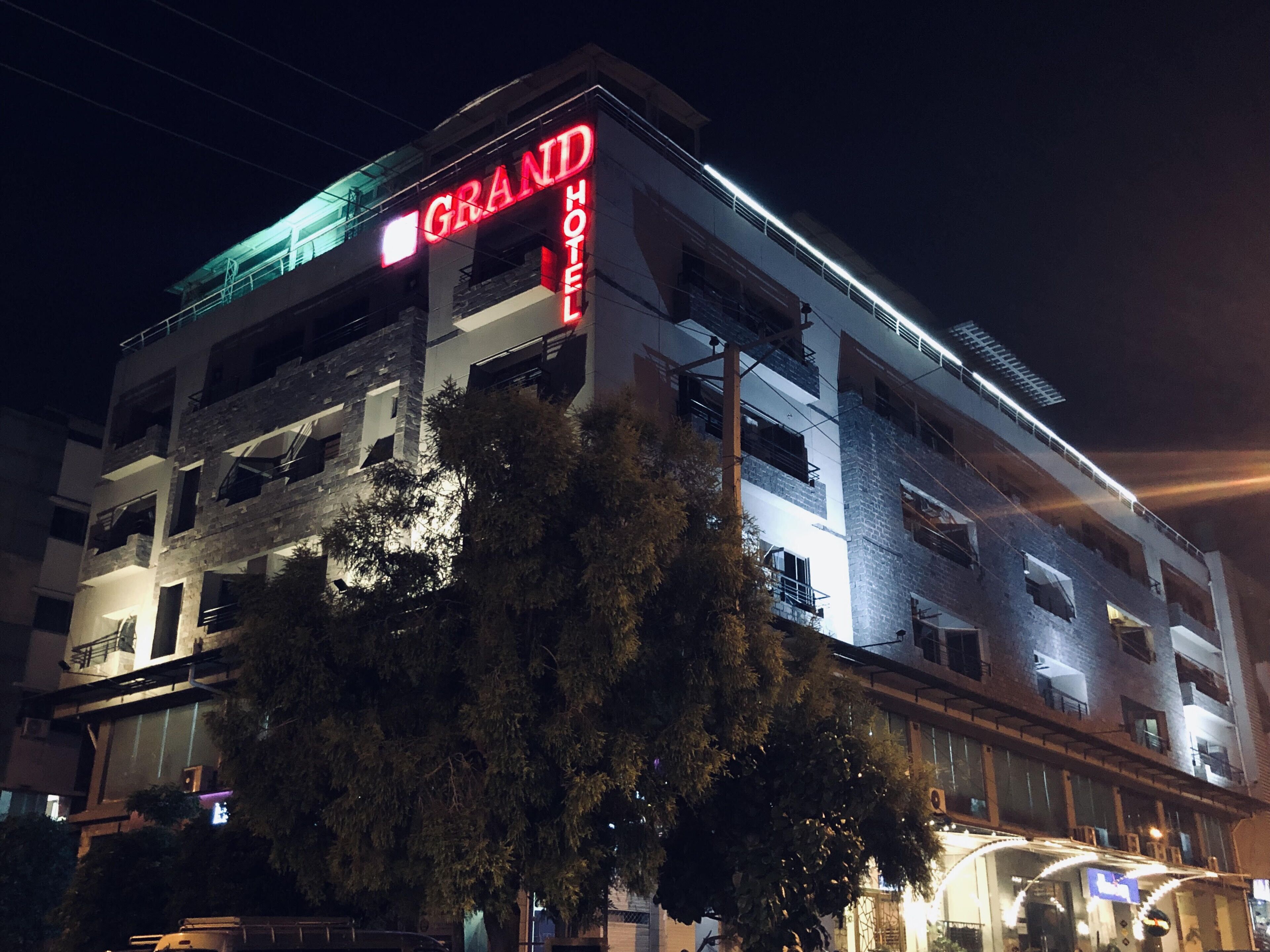 A multi-story building with a prominent 'GRAND HOTEL' sign.