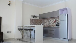 Cozinha moderna com ilha central, eletrodomésticos de aço inoxidável e painel de azulejos.