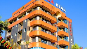 Um hotel com vários andares e varandas, com uma placa indicando 'Sheza Bldg'.