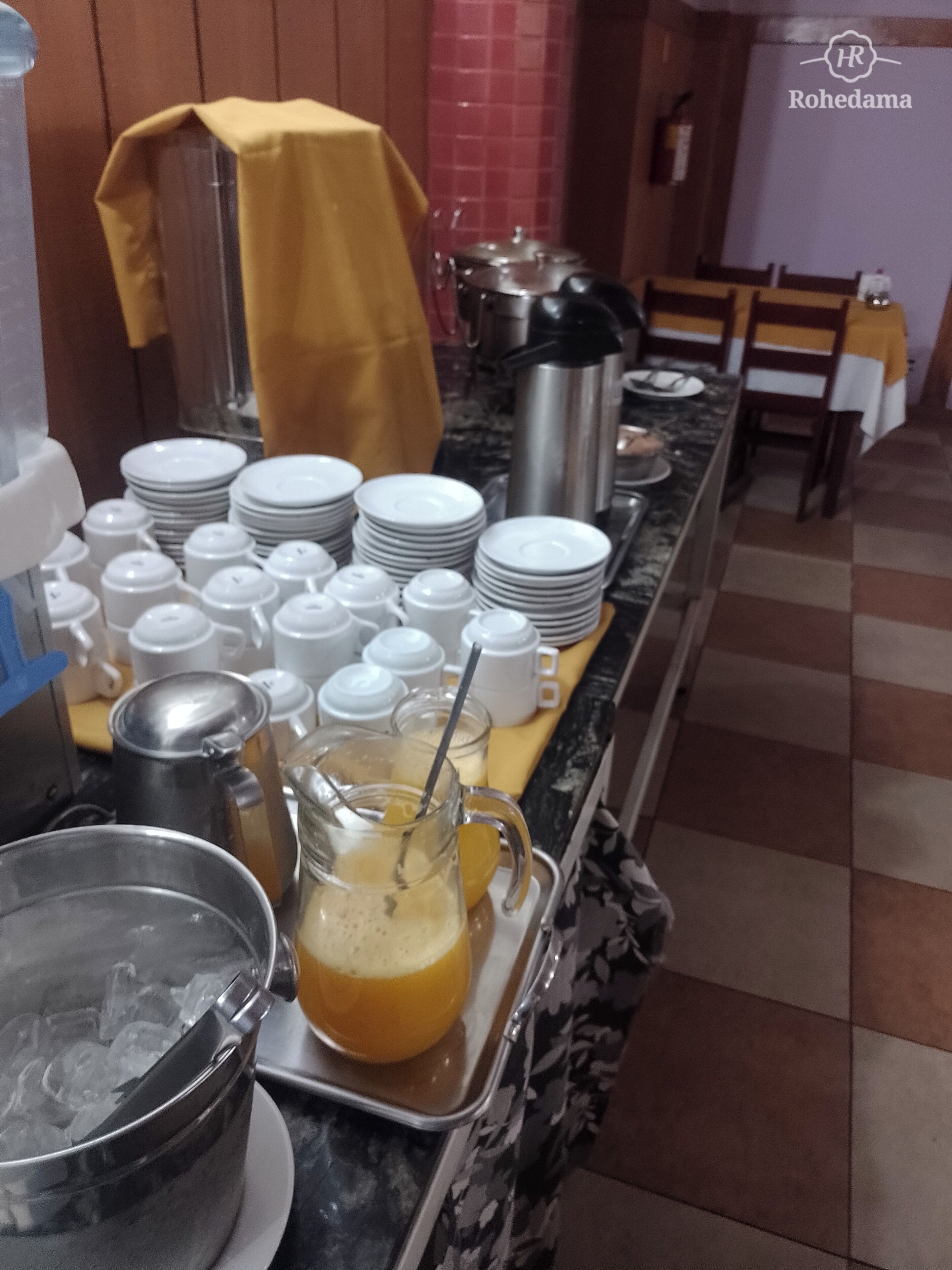 Una mesa de buffet con platos, vasos y un bol de ponche.