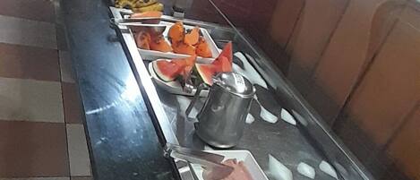 A buffet with various food items including fruits, vegetables, and dairy products.